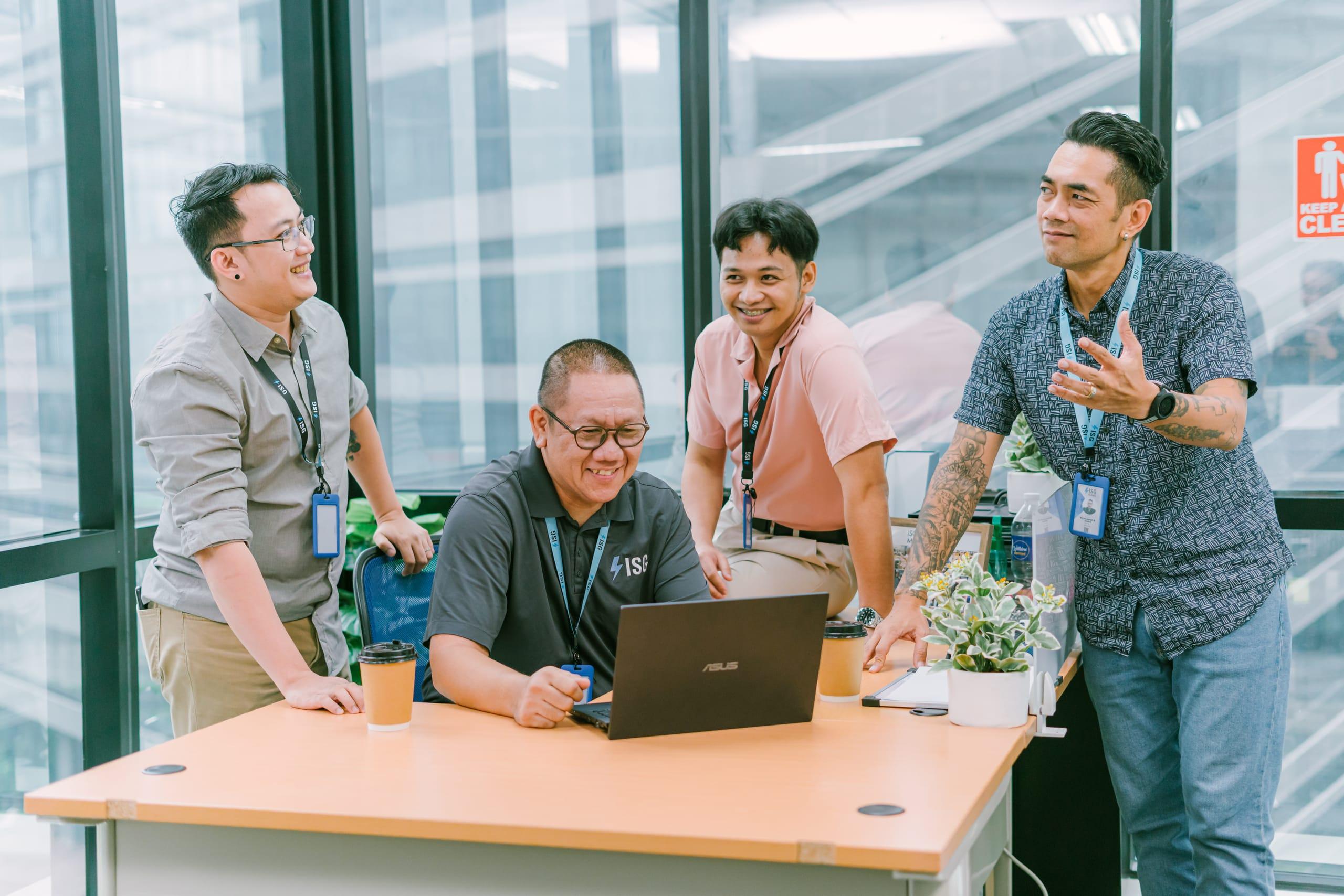 ISG teammates reviewing work together at a laptop