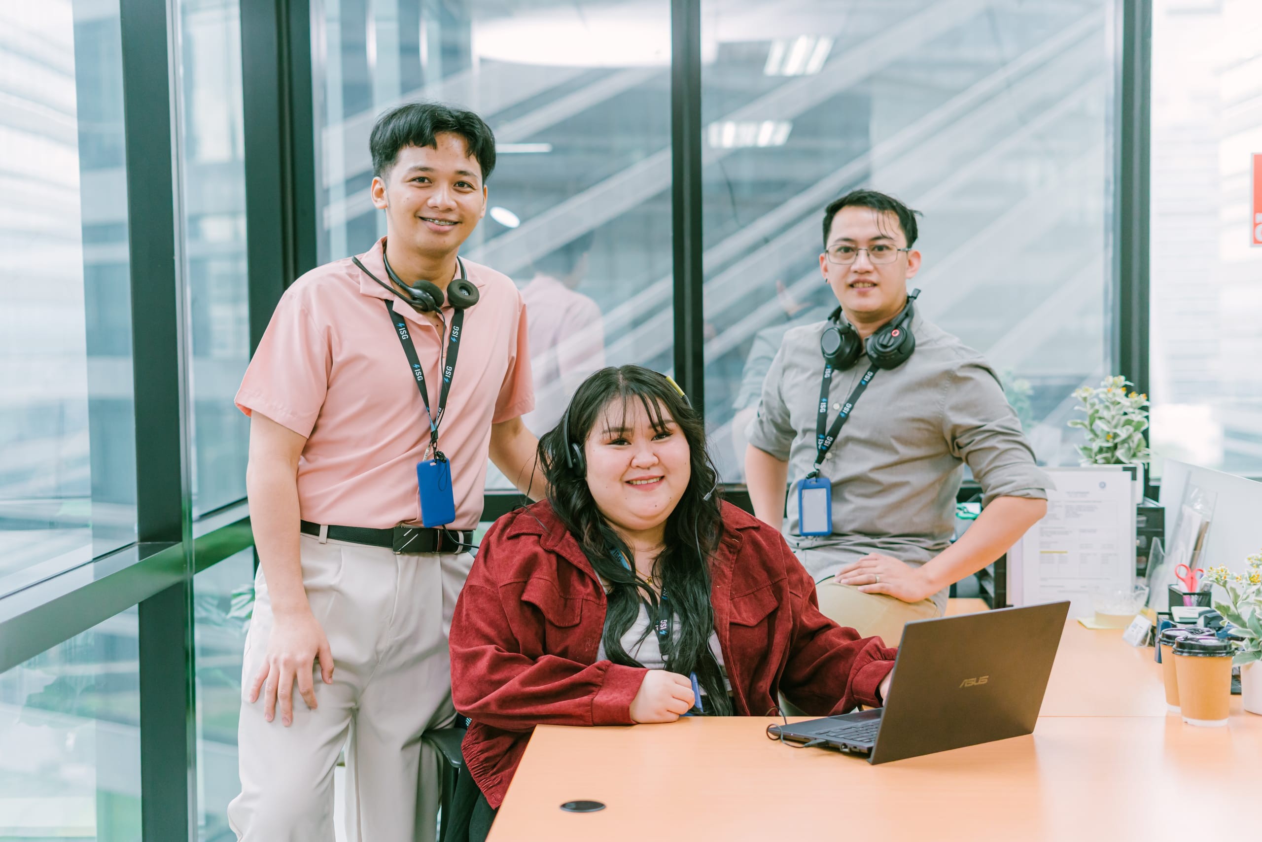 ISG teammates at a workstation, one seated at a desk with a laptop