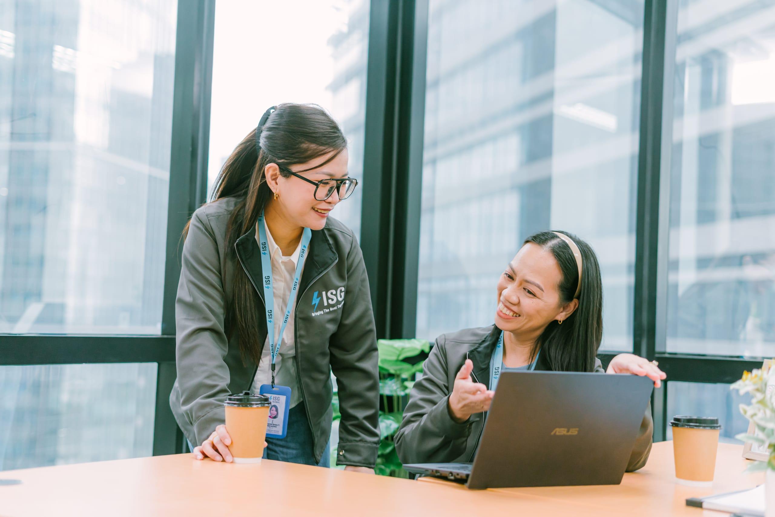 ISG teammates reviewing work together at a laptop